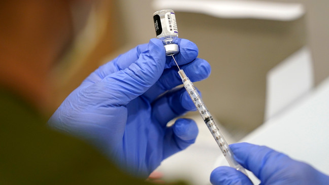FILE - A healthcare worker fills a syringe with the Pfizer COVID-19 vaccine at Jackson Memorial Hospital on Oct. 5, 2021, in Miami. (AP Photo/Lynne Sladky, File)