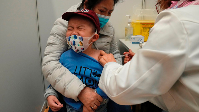 FILE - A boy receives a dose of China's Sinovac COVID-19 coronavirus vaccine at a community vaccination center in Hong Kong on Feb. 25, 2022. (AP Photo/Kin Cheung, File)