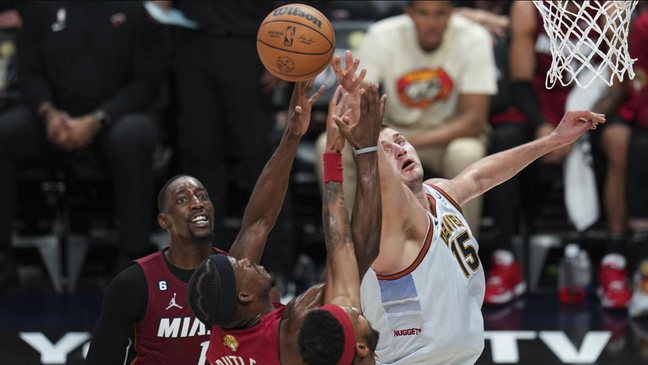 Miami Heat forward Jimmy Butler (22) and Denver Nuggets center Nikola Jokic (15) compete for possession of the ball during the first half of Game 5 of basketball's NBA Finals, Monday, June 12, 2023, in Denver. (AP Photo/Jack Dempsey)