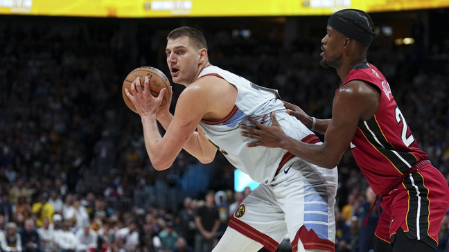 Denver Nuggets center Nikola Jokic, left, is defended by Miami Heat forward Jimmy Butler, right, during the second half of Game 5 of basketball's NBA Finals, Monday, June 12, 2023, in Denver. (AP Photo/Jack Dempsey)