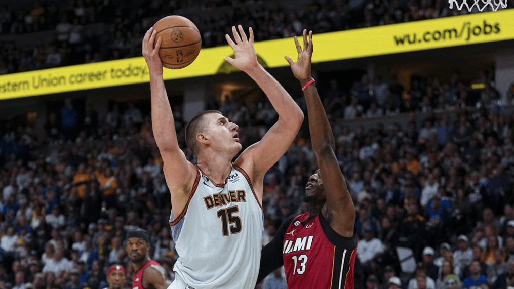 Denver Nuggets center Nikola Jokic, front left, shots over Miami Heat center Bam Adebayo, front right, during the second half of Game 5 of basketball's NBA Finals, Monday, June 12, 2023, in Denver. (AP Photo/Jack Dempsey)